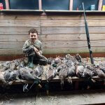 boy posing with ducks after hunt 