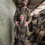 girl and man smiling for photo in duck blind