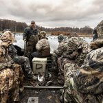 people on a boat wearing camo